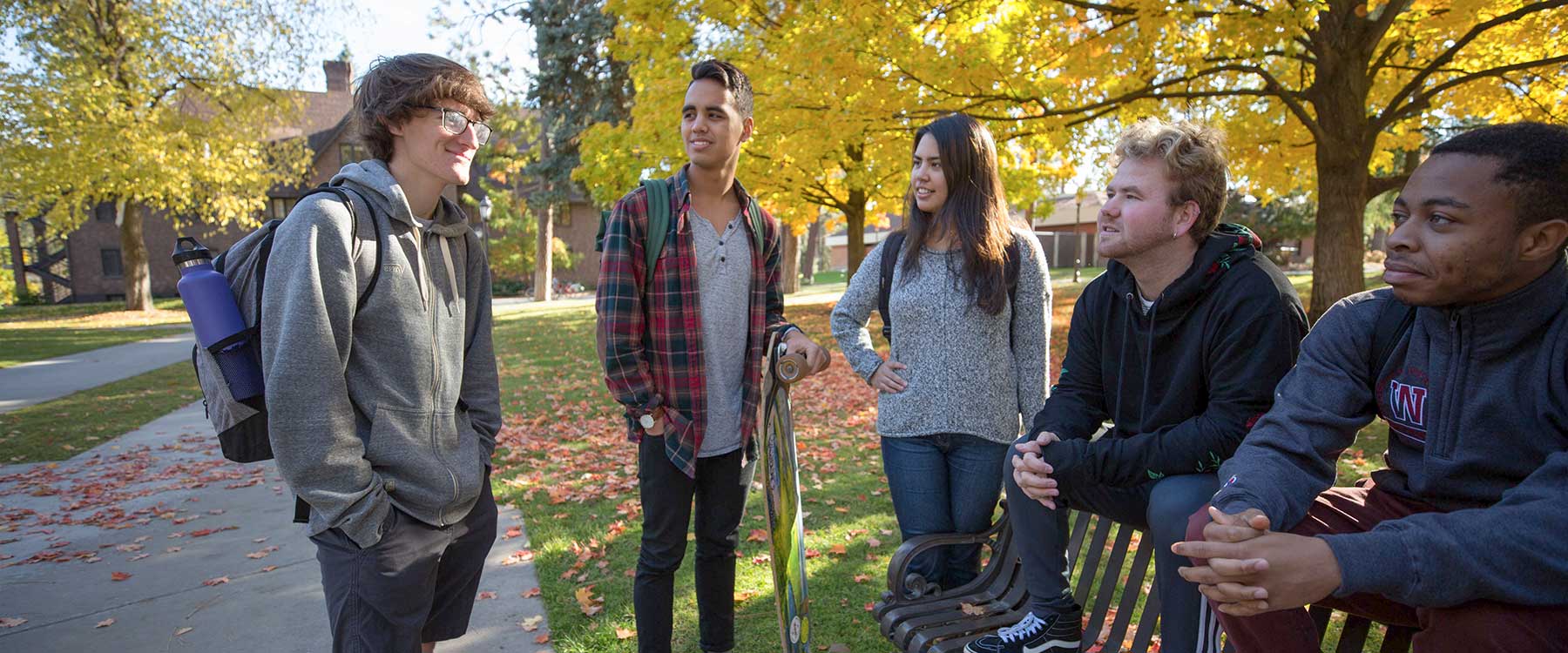 A group of students talk with one another while on campus.