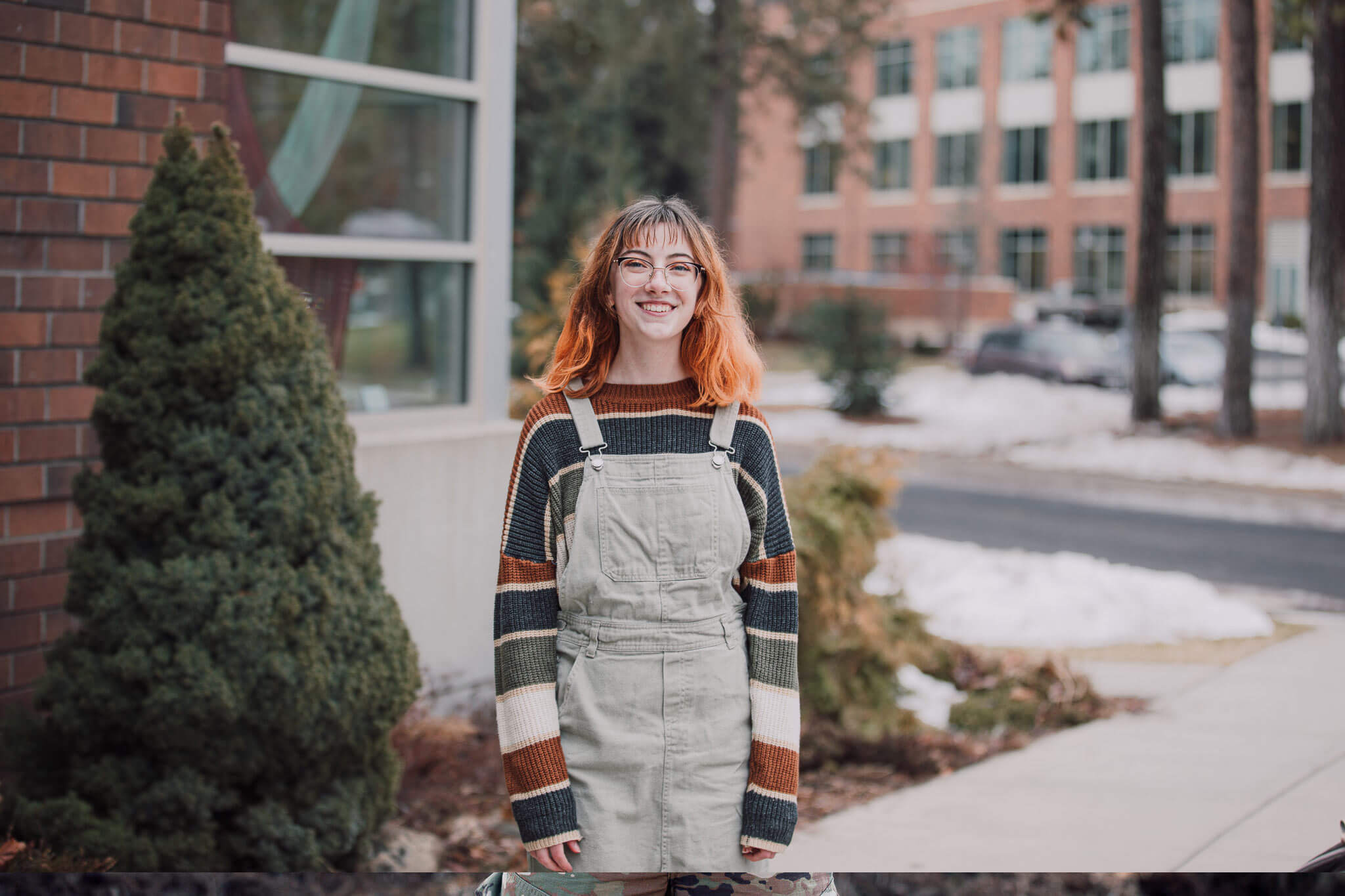 Portrait of Abby Sanders, smiling, outside an academic building with snow on the ground.