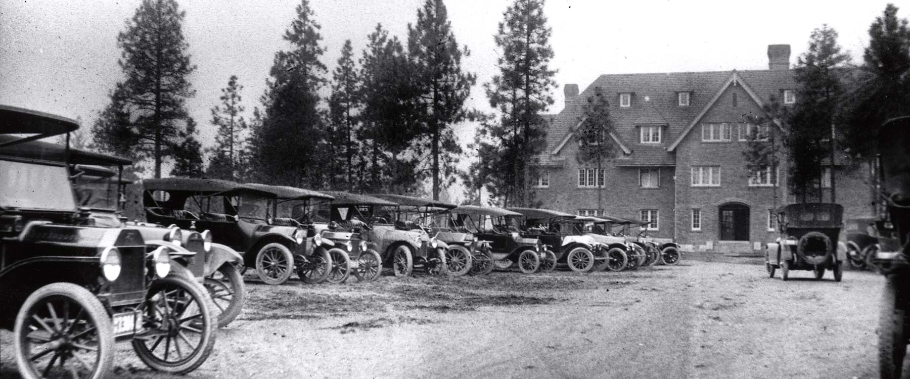 1920-1930's style cars parked in a line outside of Ballad