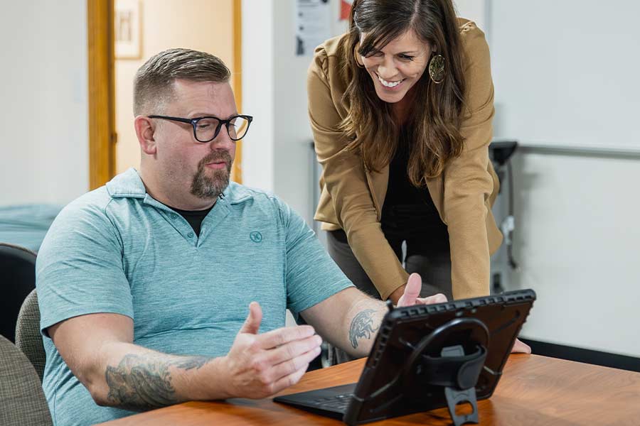 Teacher helping a student on a laptop computer