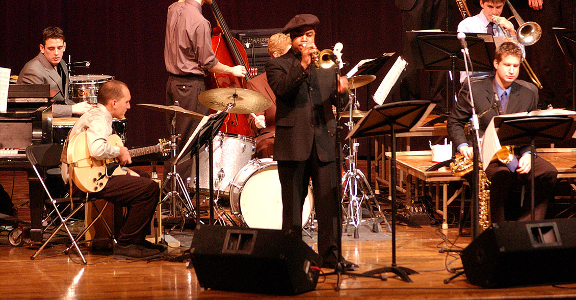 Nicholas Payton playing the trumpet in a band of students