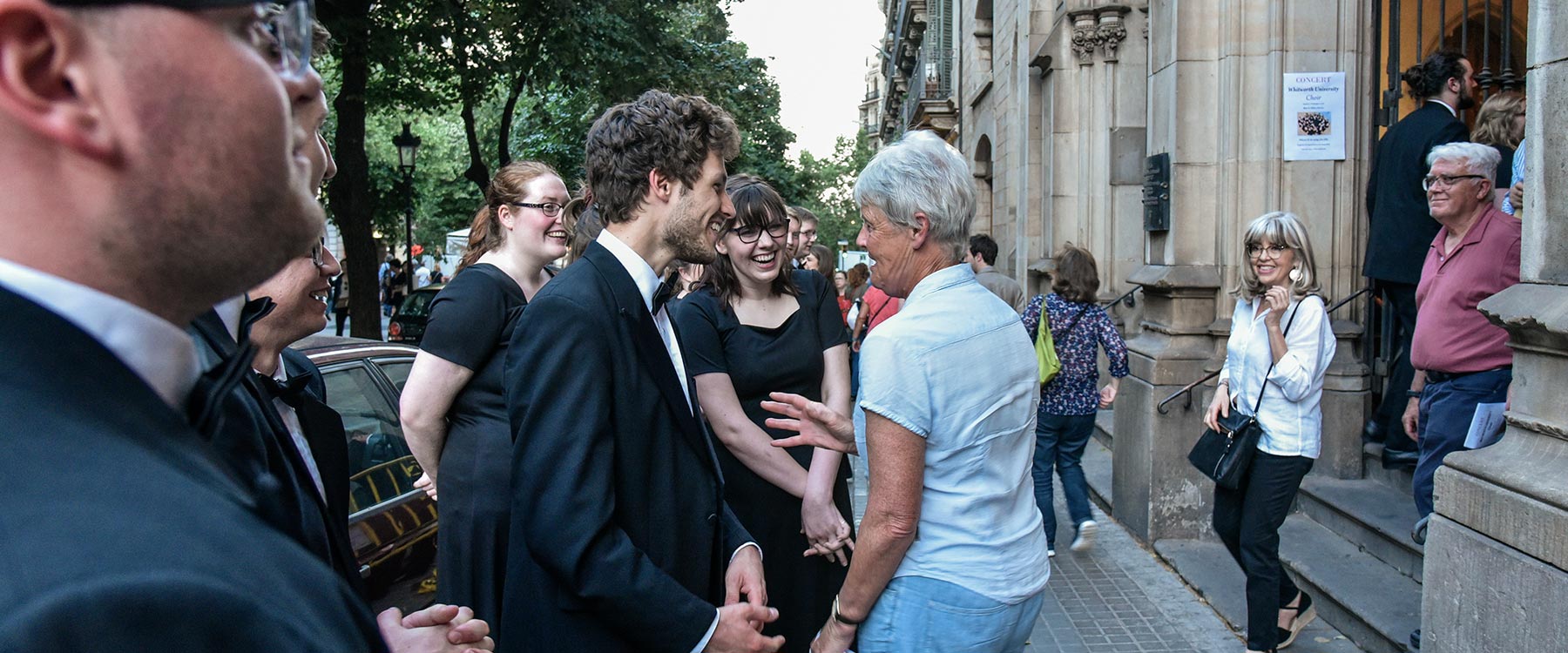 Students from the Whitworth Choir greet a concert attendee.