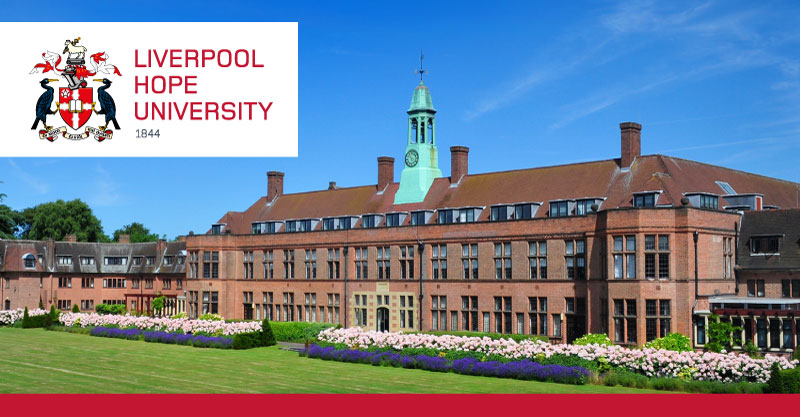 A stately brick building with immaculate landscaping.