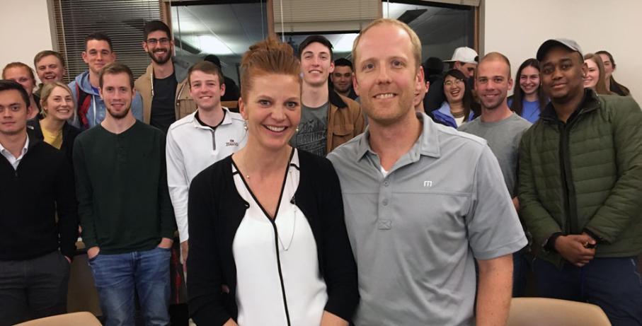 Becca Gebbers and her husband pose with a group of Whitworth business students.