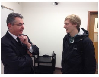 Travis Prewitt stands talking to a Whitworth business student.