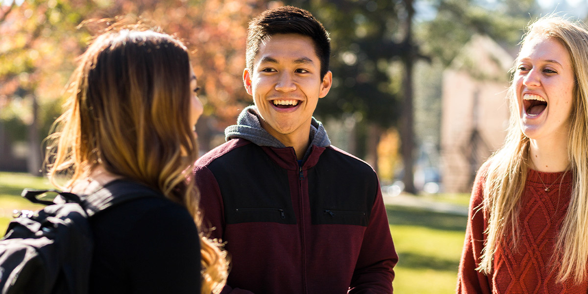 Students walking on campus smiling