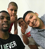 Four people lean in and smile at the camera.