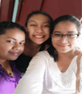 Three young adults stand close together and smile for a photo.