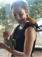 Outdoor photo portrait of Rachael Annonen with parrots.