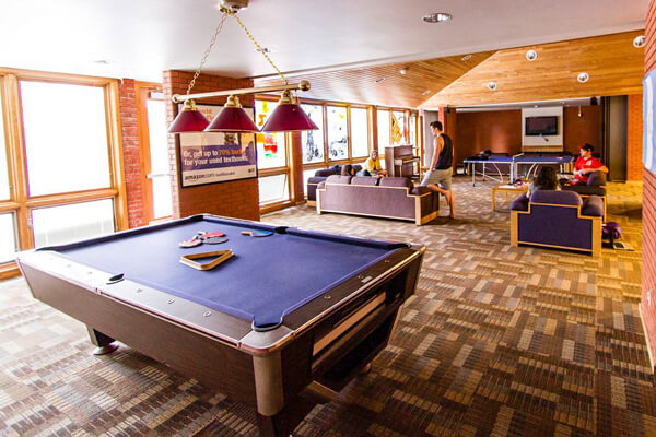 Baldwin-Jenkins common room with pool and ping-pong tables, couches and a piano.