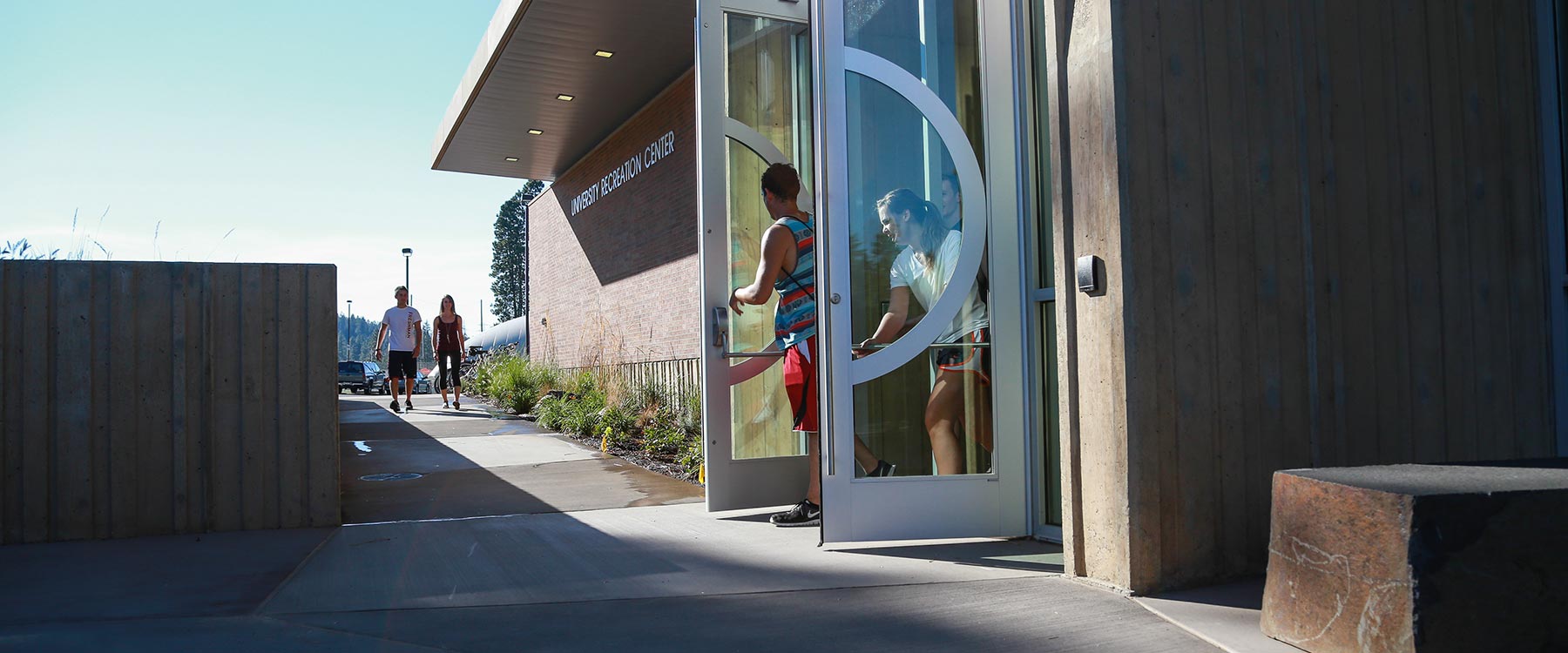 Two students push open the doors of the U-Rec as they leave.
