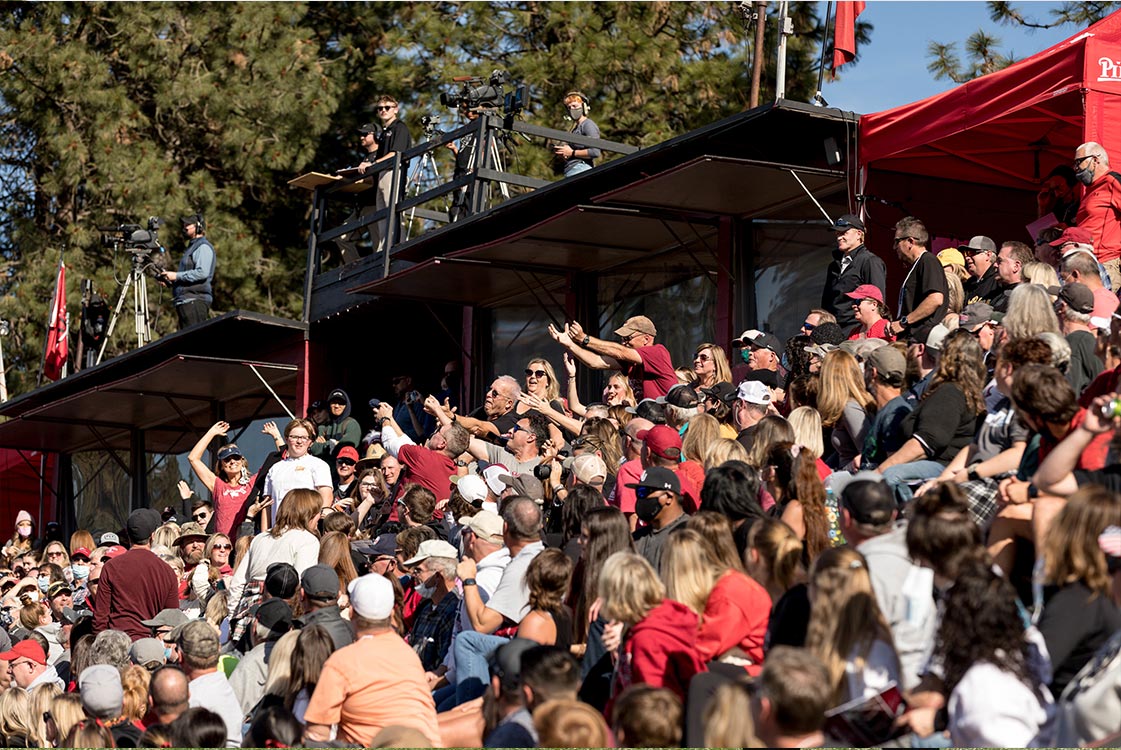 Fans cheer in the stands during a football game on campus