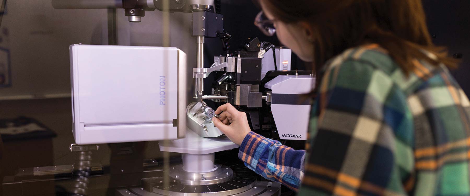 Close-up of a student examining a diffractometer.
