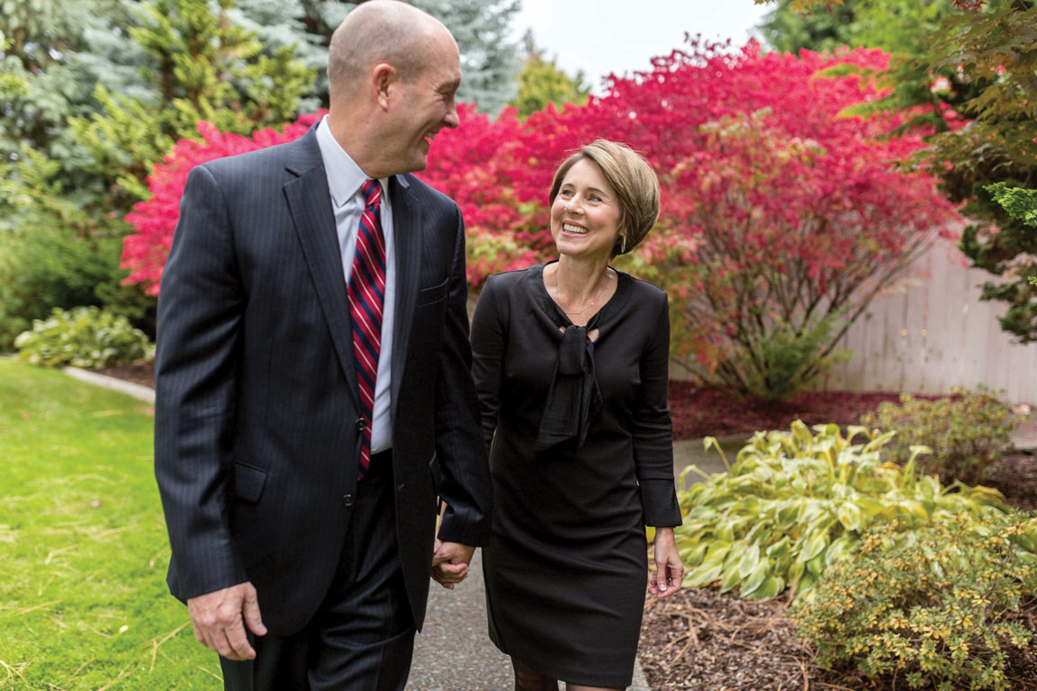 Julie Taylor and President Beck smile at one another while walking on campus