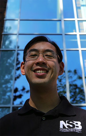 Markus Ong stands in front of Robinson Science Hall and smiles.