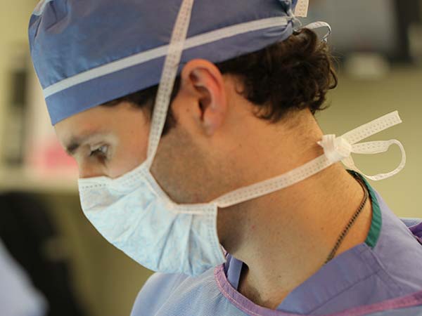 Matt Krieger wearing scrubs and a surgical mask.