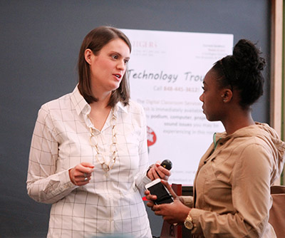 Meara Faw stands talking with a student.