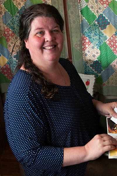 Michelle Sanders sits at a small desk and smiles.