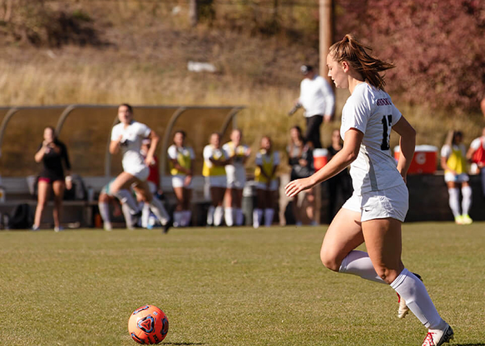 Soccer plays practice in a sunny field. One student prepares to kick the ball.