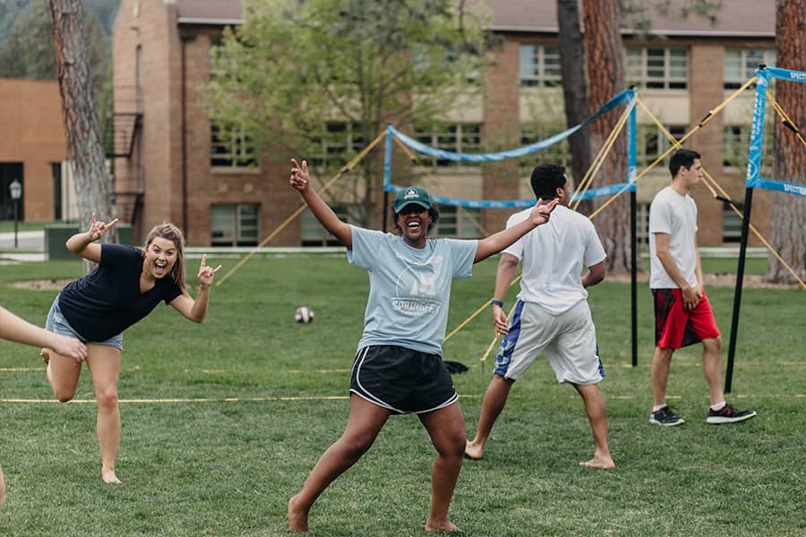 Students take a break from a volleyball game to pose for a candid photograph.