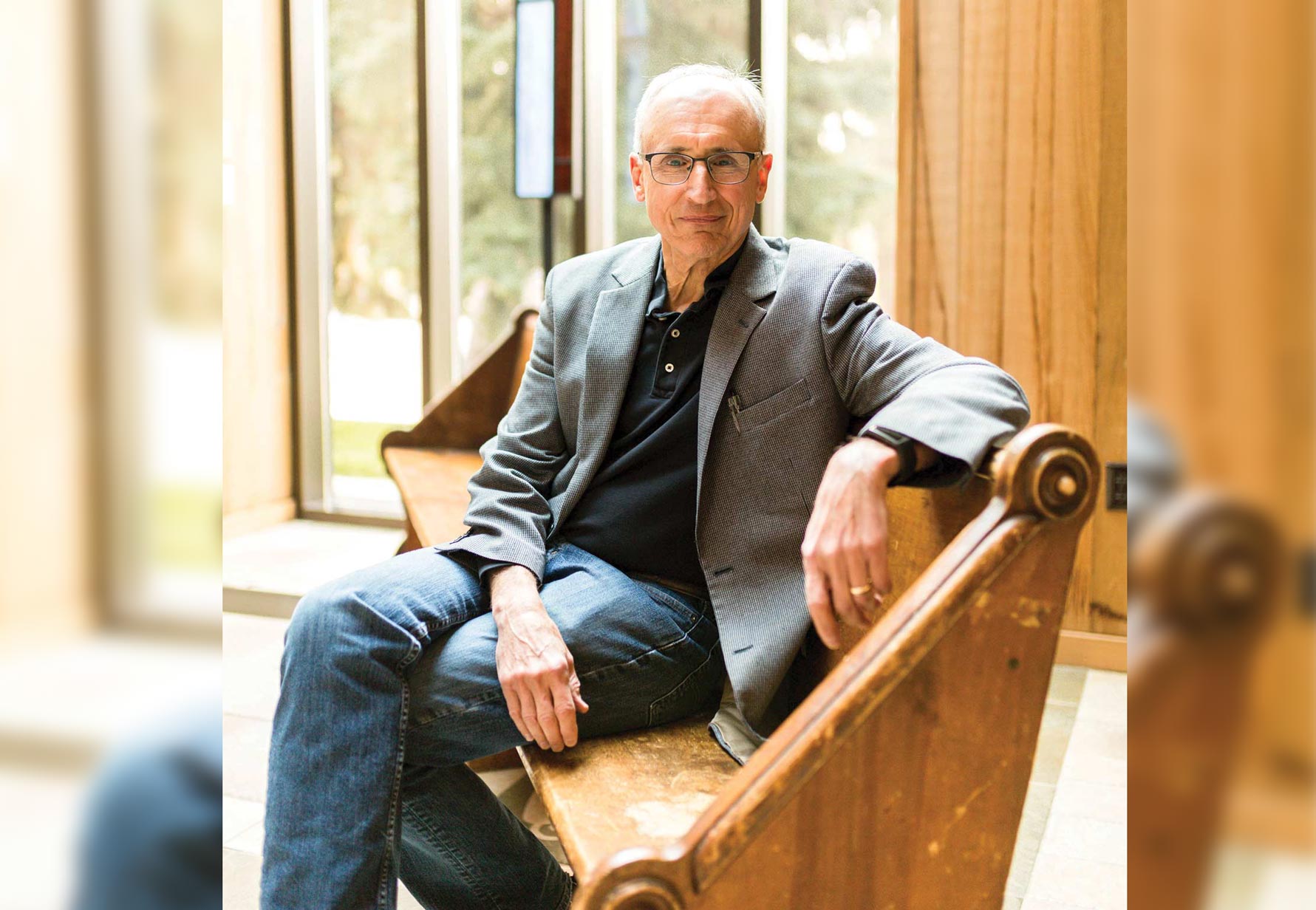 Jerry Sittser sits in a chair near a window with warm light and smiles