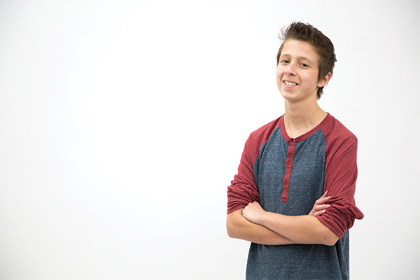 Mitch Carbon stands with arms crossed and smiles.